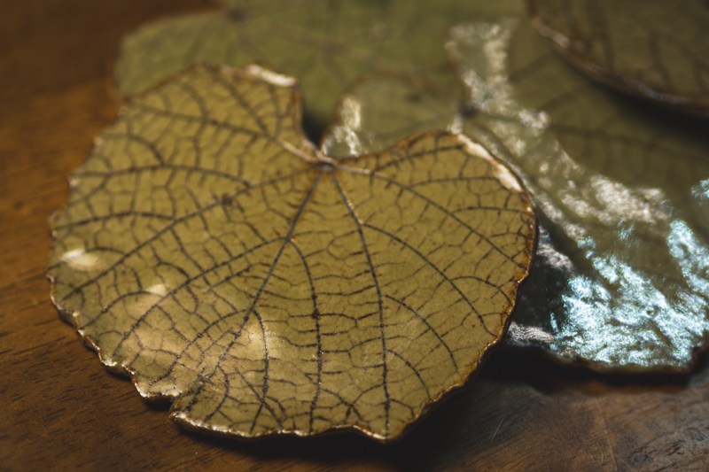 Close detail of a leaf plate showing the pressed vein pattern under a green glaze.