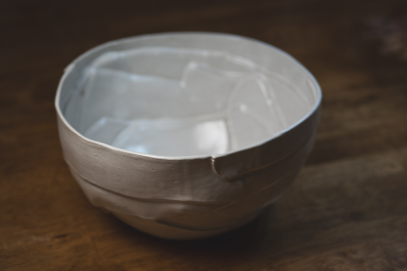 A white slab-built bowl with faceted sides and visible seams, seen from above.