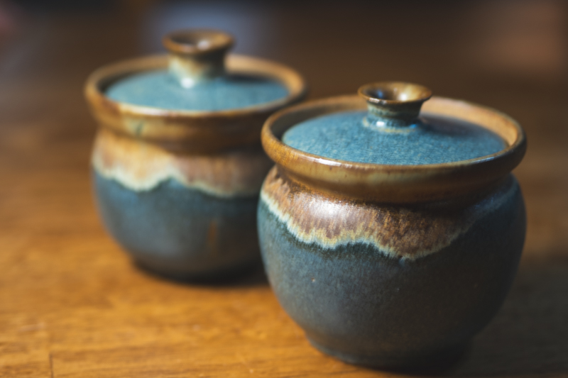 Two indigo lidded jars side by side, one slightly in front of the other.